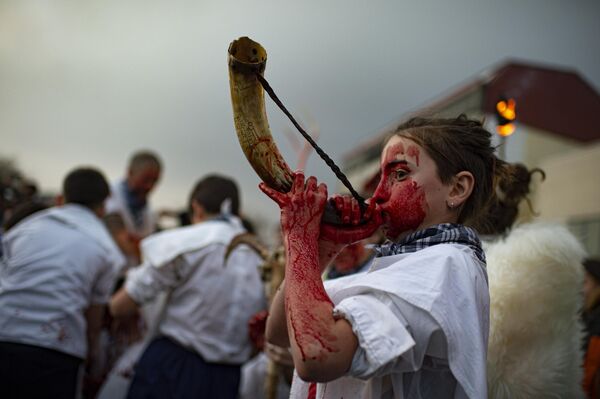 Durante el carnaval Momotxorro, personajes que parecen surgidos de un ritual prehistórico salen a la calle con cuernos, ocultando sus rostros bajo pañuelos y vestidos con una sábana blanca manchada de sangre.En la foto: Un momotxorro participa en el carnaval vestido con el traje típico del evento, Alsasua, España. - Sputnik Mundo