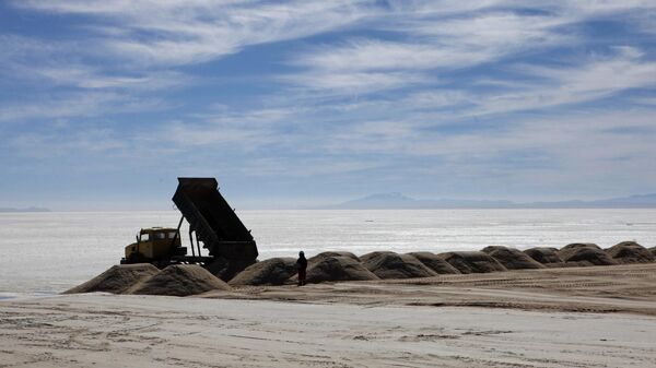 Un trabajador delante de un camión en una planta semiindustrial para producir cloruro potásico, utilizado para fabricar baterías a base de litio, el desierto de Uyuni, Bolivia - Sputnik Mundo