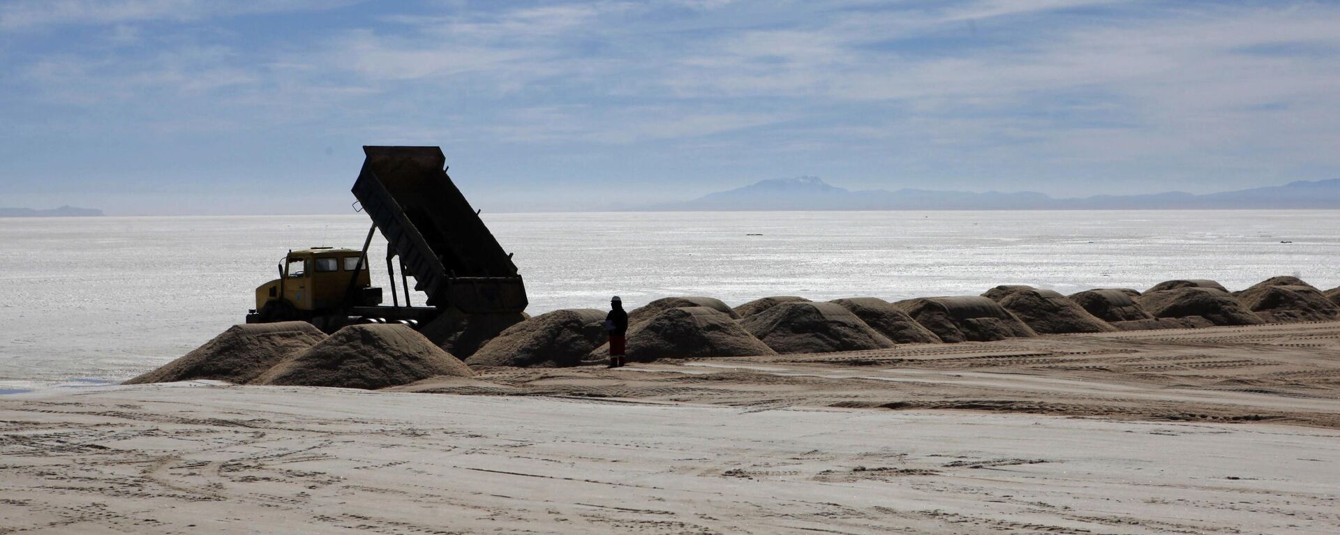 Un trabajador delante de un camión en una planta semiindustrial para producir cloruro potásico, utilizado para fabricar baterías a base de litio, en el desierto de Uyuni, Bolivia - Sputnik Mundo, 1920, 14.09.2024