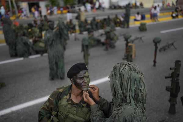 Un soldado venezolano pinta la cara de su camarada antes de un desfile con motivo del 262 aniversario del nacimiento de José María España, el primer líder de la lucha de liberación nacional contra España. - Sputnik Mundo