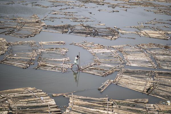 Un habitante de la aldea nigeriana de Makoko cruza un puente flotante hacia la capital de Lagos, para conocer los resultados de las elecciones presidenciales celebradas el día anterior. - Sputnik Mundo