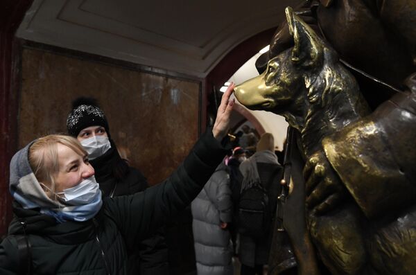 Partes de muchas esculturas de la estación Plóshchad Revolutsii están muy pulidas, ya que se cree que tocarlas trae buena suerte.En la foto: pasajeros del metro ante la escultura Guardia fronterizo con perro en la estación Ploshchad Revolutsii de la línea 3 (azul). - Sputnik Mundo