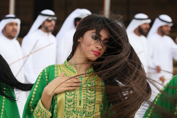 Una mujer baila una danza tradicional en un festival de camellos en las afueras de Abu Dabi, EAU. - Sputnik Mundo