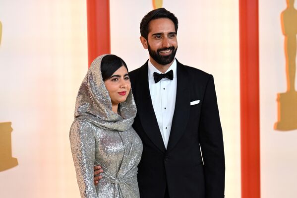 La activista pakistaní por los derechos humanos y Premio Nobel de la Paz Malala Yousafzai, con un conjunto de Ralph Lauren junto a su marido Asser Malik en la alfombra de la 95 edición de los Óscar. - Sputnik Mundo