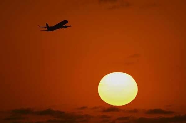 Diferentes ciudades de la provincia de Buenos Aires tienen vigentes los niveles de peligro meteorológico naranja y rojo.En la foto: un avión frente a la puesta de sol sobre Buenos Aires. - Sputnik Mundo