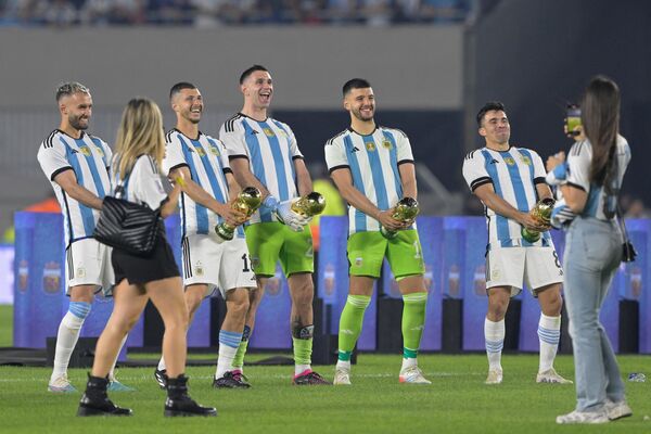 Integrantes de la selección de Argentina, campeones del mundo 2022, con ejemplares de la Copa del torneo de Qatar tras ganar un amistoso contra Panamá en el estadio Monumental de Buenos Aires, el 24 de marzo de 2023. - Sputnik Mundo