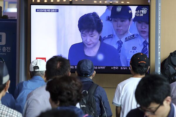 La gente mira una pantalla de televisión que muestra a la expresidenta surcoreana Park Geun-hye, durante un programa de noticias en la estación de tren de Seúl. El máximo tribunal de Corea del Sur devolvió el caso de corrupción de Park a un tribunal inferior para que se celebren juicios separados por sus cargos previamente condenados, un fallo que podría aumentar su ya larga pena de prisión. - Sputnik Mundo