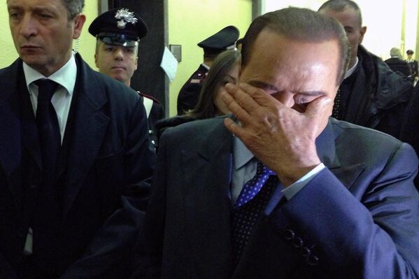 El ex primer ministro italiano Silvio Berlusconi reacciona en un pasillo del tribunal de Milán durante una vista del juicio a Mediaset, 1 de marzo de 2013. Berlusconi fue juzgado en los tribunales italianos por varios casos, entre los cargos que se le imputaban figuraban soborno, fraude fiscal y pago por mantener relaciones sexuales con una prostituta menor de edad. - Sputnik Mundo