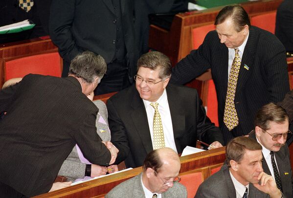 El ex primer ministro ucraniano Pavló Lazarenko, en el centro de la imagen, sonríe mientras es recibido por diputados en el Parlamento de Ucrania, martes 22 de diciembre de 1998. Lazarenko salió en libertad bajo fianza de 3 millones de dólares de una cárcel suiza en 1999, tras ser detenido por la policía suiza acusado de blanqueo de dinero. - Sputnik Mundo