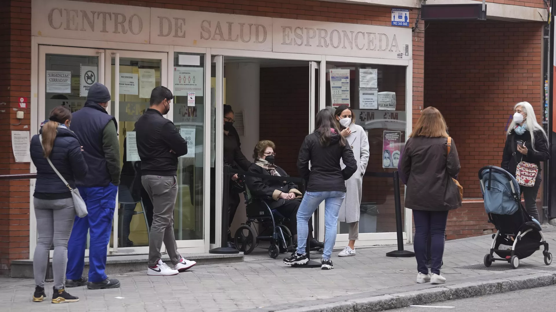 Varias personas hacen cola frente a un centro de salud local en Madrid, España