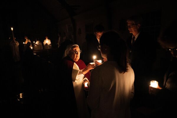 Hoy en día, la Pascua católica se celebra el primer domingo después de la primera luna llena que sigue al equinoccio de primavera. En la foto: un oficio de la noche de Pascua en una iglesia de Washington, EEUU. - Sputnik Mundo