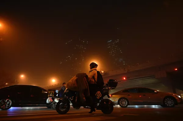 Una mujer monta en scooter en el centro de negocios de Pekín durante una tormenta de arena. Una mujer monta en scooter en el centro de negocios de Pekín durante una tormenta de arena. - Sputnik Mundo