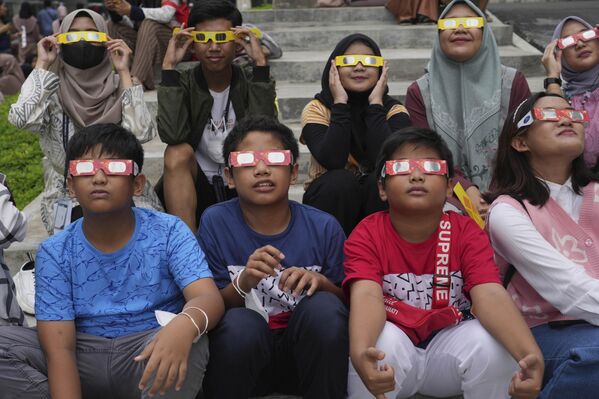 La fase total del eclipse fue visible en Timor Oriental, partes de Papúa Occidental y la península de Exmouth, en Australia Occidental.En la foto: unos jóvenes indonesios llevan gafas protectoras para ver el fenómeno astronómico en Yakarta, Indonesia. - Sputnik Mundo