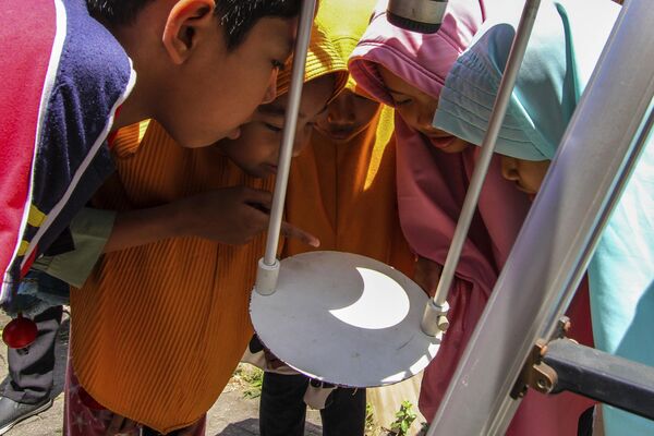 Los residentes de Australia, Nueva Zelanda, Indonesia, Filipinas y algunos otros países del sudeste asiático pudieron observar la fase parcial del eclipse.En la foto: unos niños observan el eclipse solar reflejado en la base de un telescopio en Yakarta, Indonesia. - Sputnik Mundo