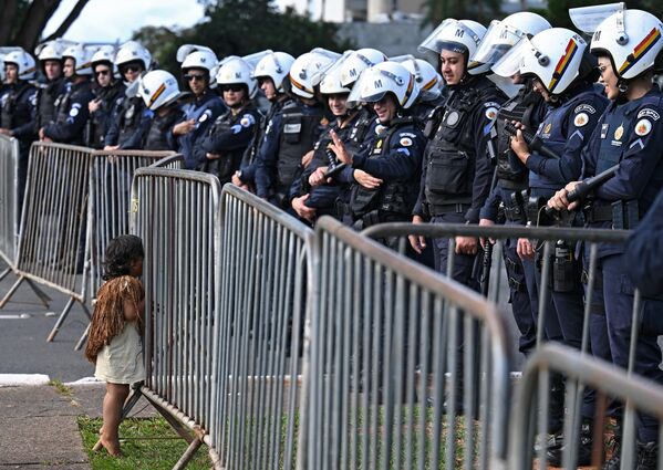 Policías brasileños y un niño del campamento de protesta indígena Terra Livre ante el edificio del Congreso, en el centro de Brasilia. - Sputnik Mundo