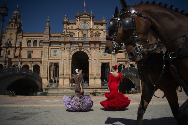 Mujeres con trajes tradicionales en la Plaza de España de Sevilla, España, donde hace un calor anormal. - Sputnik Mundo