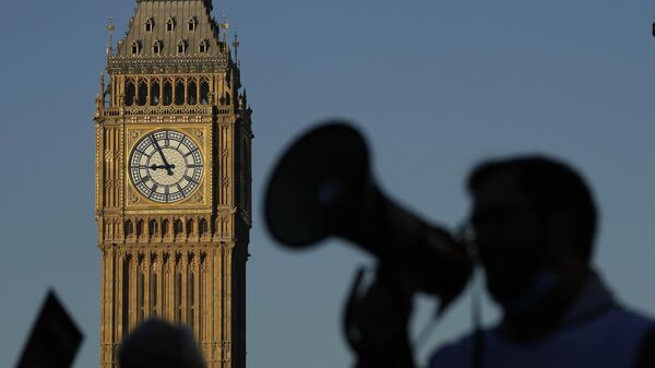 Un manifestante con un megáfono grita consignas frente al Big Ben mientras las enfermeras del cercano hospital St. Thomas protestan en Londres, el lunes 6 de febrero de 2023. - Sputnik Mundo