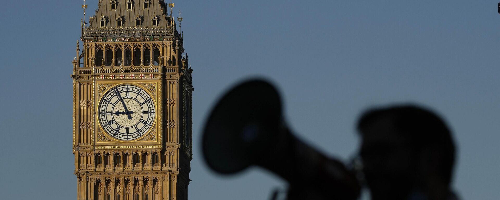 Un manifestante con un megáfono grita consignas frente al Big Ben mientras las enfermeras del cercano hospital St. Thomas protestan en Londres, el lunes 6 de febrero de 2023. - Sputnik Mundo, 1920, 14.08.2024