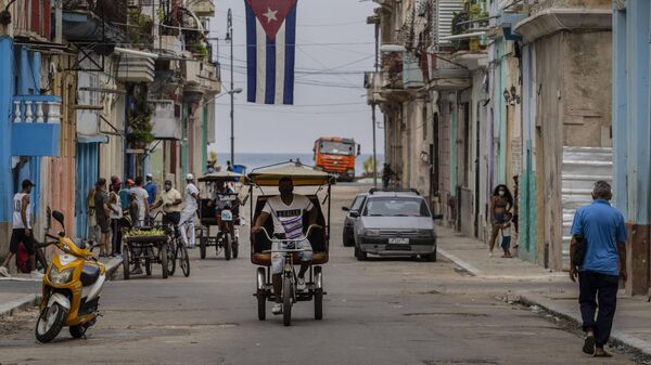 Un hombre monta en un bicitaxi por las calles de La Habana, Cuba - Sputnik Mundo