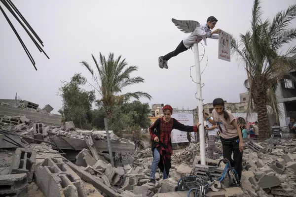 Niñas palestinas ante la imagen de un adolescente palestino muerto instalada sobre las ruinas de un edificio residencial destruido en Deir al-Balah, en el marco de la exposición "La ocupación mata a la infancia". Niñas palestinas ante la imagen de un adolescente palestino muerto instalada sobre las ruinas de un edificio residencial destruido en Deir al-Balah, en el marco de la exposición "La ocupación mata a la infancia". - Sputnik Mundo