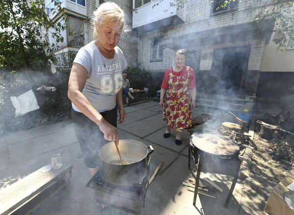 La prueba de la intencionalidad de las acciones de Kiev para inundar la región de Jersón es el hecho sin precedentes de que las cuatro esclusas de la Estación Hidroeléctrica Dniéper, aguas arriba, estuvieron abiertas durante el tiempo récord de unas dos semanas.En la foto: mujeres cocinan alimentos en el patio de una casa de la localidad de la ciudad de Gólaya Pristan, región de Jersón. - Sputnik Mundo