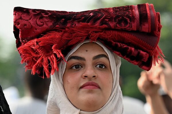 En los países donde el Islam es la religión del Estado, este día es fiesta oficial. En la foto: una mujer musulmana sostiene una alfombra de oración en la Tribuna Quirino en Manila, Filipinas. - Sputnik Mundo