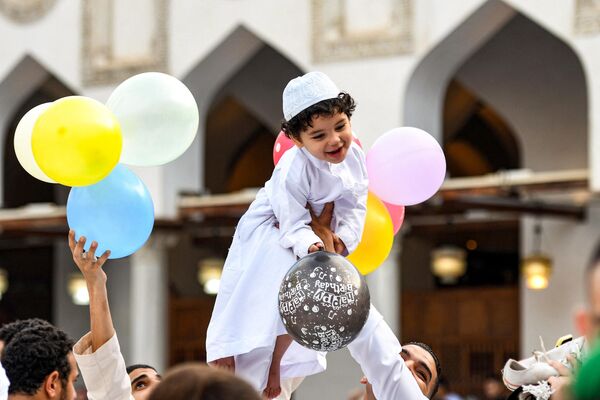 Si un musulmán no puede permitirse comprar un carnero para el sacrificio, se pone de acuerdo con parientes, vecinos o amigos para realizar juntos el ritual. En la foto: un niño en brazos de su padre tras la oración festiva en El Cairo. - Sputnik Mundo