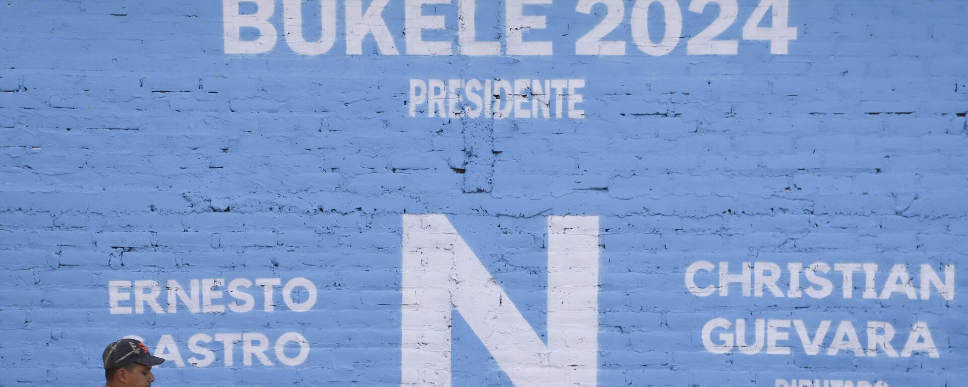 Un residente pasa junto a un cartel electoral del partido Nuevas Ideas que promueve la reelección del presidenteб Nayib Bukeleб en Soyapango Un residente pasa junto a un cartel electoral del partido Nuevas Ideas que promueve la reelección del presidenteб Nayib Bukeleб en Soyapango - Sputnik Mundo, 1920, 30.06.2023