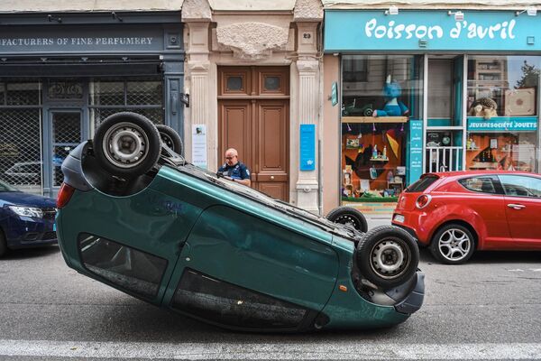 Por internet ha circulado un video en el que se afirma que inmigrantes sirios atacaron a un francés nativo cuando intentaba defender su coche de un incendio, y le cortaron ambos brazos. En la foto: un coche volcado en una calle de la ciudad francesa de Lyon. - Sputnik Mundo