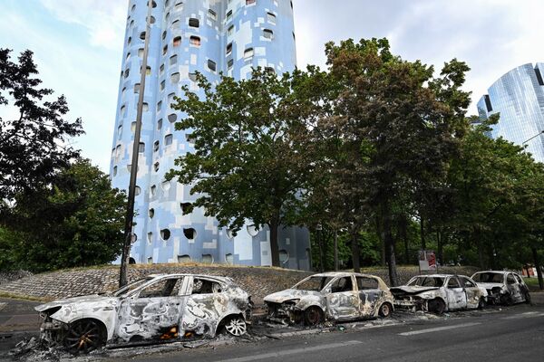 La causa formal de los disturbios fue la muerte en el suburbio parisino de Nanterre de Nahel Merzouk, de 17 años. El ciudadano argelino trabajaba como mensajero en un coche y fue detenido por la policía por una infracción de tráfico. Cuando el infractor intentó darse a la fuga, el policía que lo retenía a punta de pistola consiguió dispararle, hiriendo mortalmente al adolescente.En la foto: coches quemados en la ciudad francesa de Nanterre. - Sputnik Mundo