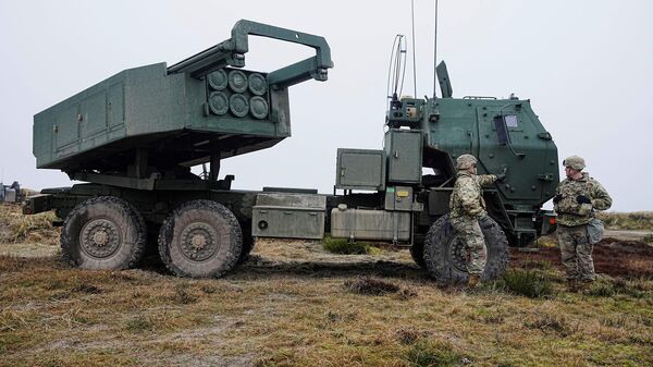 Soldados frente a un Sistema de Cohetes de Artillería de Alta Movilidad Himars durante el ejercicio militar Dynamic Front liderado por EEUU en Dinamarca, el 30 de marzo de 2023. - Sputnik Mundo