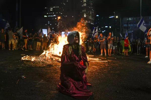 Un manifestante vestido como un personaje de la serie de televisión El cuento de la criada bloquea una autopista en la capital israelí, Tel Aviv. Miles de judíos salieron a la calle y bloquearon varias autopistas importantes en todo el país para protestar contra la reforma judicial. Un manifestante vestido como un personaje de la serie de televisión El cuento de la criada bloquea una autopista en la capital israelí, Tel Aviv. Miles de judíos salieron a la calle y bloquearon varias autopistas importantes en todo el país para protestar contra la reforma judicial. - Sputnik Mundo