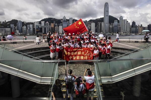 Varias personas celebran en el paseo marítimo de Tsim Sha Tsui, en Hong Kong, el 26 aniversario de la devolución de Hong Kong a la jurisdicción china tras más de un siglo y medio de dominio colonial británico. - Sputnik Mundo