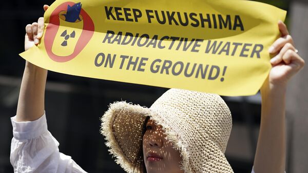 Una manifestante sostiene una pancarta durante una concentración frente a la sede de Tokyo Electric Power Company Holdings (TEPCO) el 16 de mayo de 2023, en Tokio - Sputnik Mundo