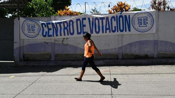 Una mujer pasa junto a un colegio electoral en San José del Golfo, Guatemala, el 26 de junio de 2023 - Sputnik Mundo