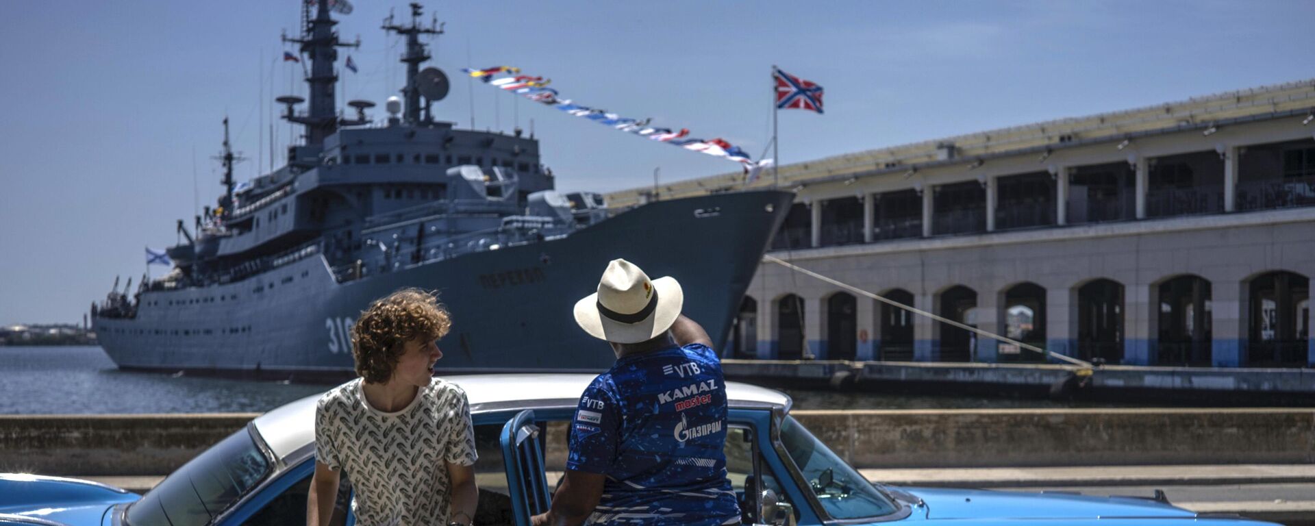 Туристка выходит из классического американского автомобиля перед учебным кораблем ВМФ России Перекоп в Гаванской бухте, Куба - Sputnik Mundo, 1920, 12.07.2023