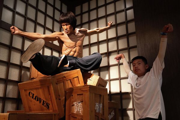 Bruce Lee, uno de los primeros actores asiáticos en alcanzar el éxito en Hollywood, nació en San Francisco el 27 de noviembre de 1940 durante la gira americana de sus padres, artistas de profesión. El padre de la futura estrella era chino y su madre medio alemana, que creció en la familia de un magnate de Hong Kong. En la foto: un turista se hace una foto con una figura de cera de Bruce Lee en el Museo Madame Tussauds de Hong Kong. - Sputnik Mundo