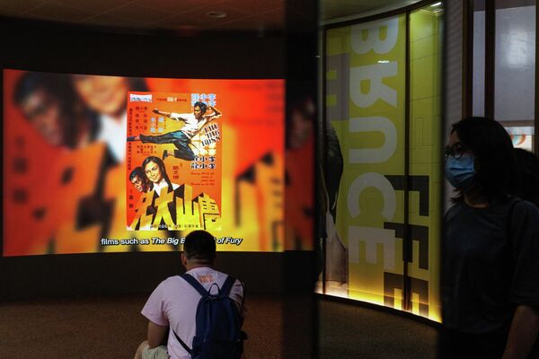 Las películas protagonizadas por Bruce Lee desataron una locura masiva por el kung-fu en todo el mundo. En la foto: fans de Bruce Lee viendo un documental sobre su vida en una exposición en el Museo del Patrimonio de Hong Kong. - Sputnik Mundo