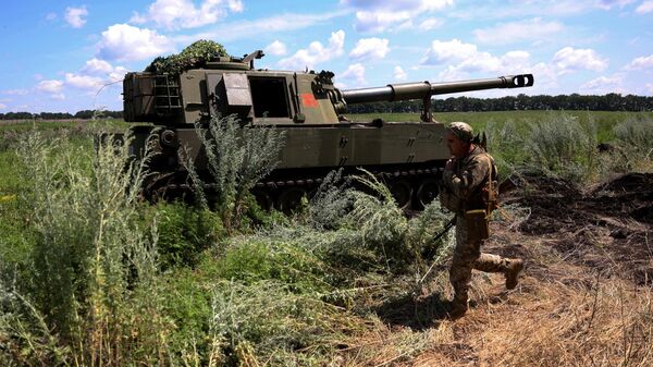 Un soldado ucraniano camina frente a un obús autopropulsado M109  - Sputnik Mundo