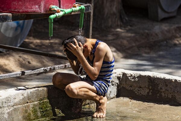 Es probable que julio sea calificado como el mes más caluroso en la Tierra en cientos, o hasta quizás en miles de años, declaró a la prensa Gavin Schmidt, director del Instituto Goddard de Estudios Espaciales de la NASA. En la foto: un niño se moja con agua durante un día caluroso en un campo de evacuados de la provincia de Hasakeh, en el noreste de Siria. - Sputnik Mundo