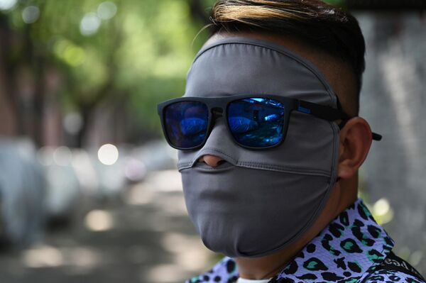 Zonas desde el sur y el oeste de Estados Unidos hasta Italia y Grecia en Europa, China y Japón en Asia están batiendo récords de temperaturas.En la foto: un hombre lleva una máscara solar en una calle de Pekín, China. - Sputnik Mundo