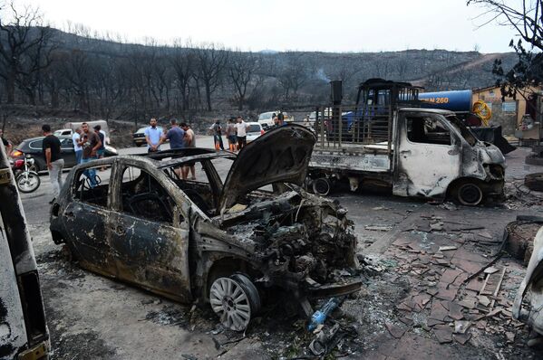 En Argelia, el número de muertos como consecuencia de los incendios forestales, según los últimos datos, asciende a 34 personas, entre ellas 10 soldados que participaron en la extinción del fuego. Ya evacuaron a cerca de 1.500 personas de las provincias de Bejaia, Buira y Jijel.En la foto: las consecuencias del desastre natural en la provincia de Bouira. - Sputnik Mundo