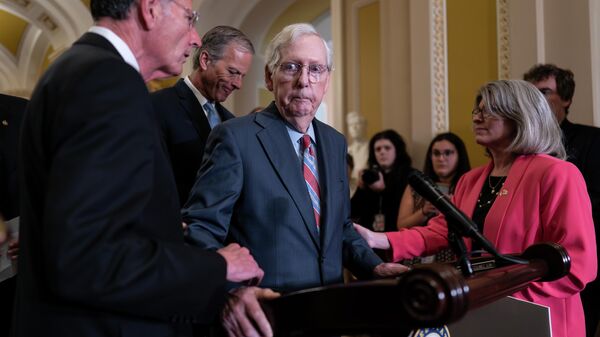 El líder del Senado republicano Mitch McConnel es ayudado por otros legisladores tras congelarse al comenzar una conferencia de prensa - Sputnik Mundo