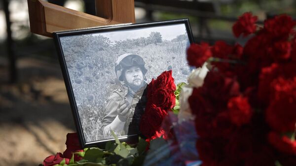 Retrato y flores en la tumba del corresponsal de guerra de Sputnik, Rostislav Zhuravliov - Sputnik Mundo