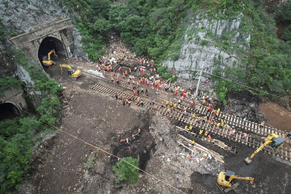 Los equipos de emergencia utilizan maquinaria pesada, botes de rescate y ambulancias para llegar a las zonas afectadas. En la foto: la reconstrucción de una vía férrea en Pekín. - Sputnik Mundo