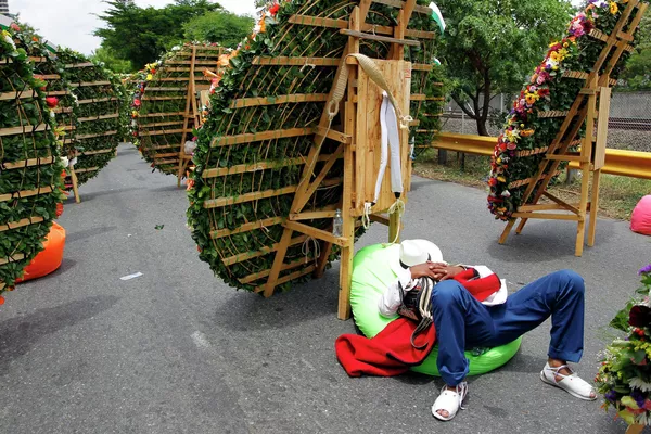 Un participante en el Desfile de Silleteros de Medellín descansa junto a unos ramos de flores. Un participante en el Desfile de Silleteros de Medellín descansa junto a unos ramos de flores. - Sputnik Mundo
