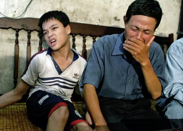 Nguyen Van Quy, de 49 años, con su hijo de 17 años, Nguyen Quang Trung, que nació con discapacidades físicas y mentales debido a la exposición de su padre al agente naranja durante la guerra, Hai Phong, Vietnam, 2004. Nguyen Van Quy, de 49 años, con su hijo de 17 años, Nguyen Quang Trung, que nació con discapacidades físicas y mentales debido a la exposición de su padre al agente naranja durante la guerra, Hai Phong, Vietnam, 2004. - Sputnik Mundo