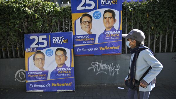 Una mujer mira pancartas electorales que representan al candidato presidencial ecuatoriano Fernando Villavicencio, Quito, el 10 de agosto de 2023 - Sputnik Mundo