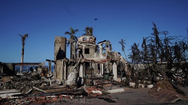 Los habitantes de Hawái se encontraron en el epicentro del apocalipsis: debido al calor y la sequía en la isla de Maui, se produjeron potentes incendios forestales, y los fuertes vientos de la tormenta tropical Dora los propagaron instantáneamente por las zonas urbanas. Una de las primeras en arder fue el popular centro histórico y turístico de Lahaina. En la foto: un edificio quemado en Lahaina. - Sputnik Mundo