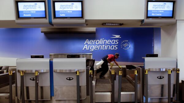 Un trabajador limpia el mostrador de facturación de Aerolíneas Argentinas en el aeropuerto de Buenos Aires, Argentina  - Sputnik Mundo